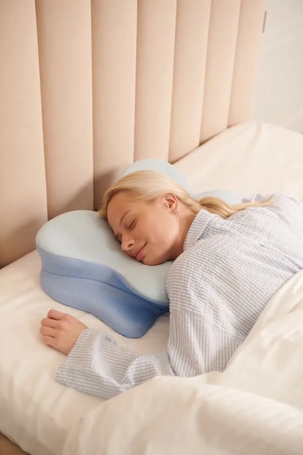 Side sleeper resting on the Derila Ergo pillow with the shoulder tucked into the gap between the wings
