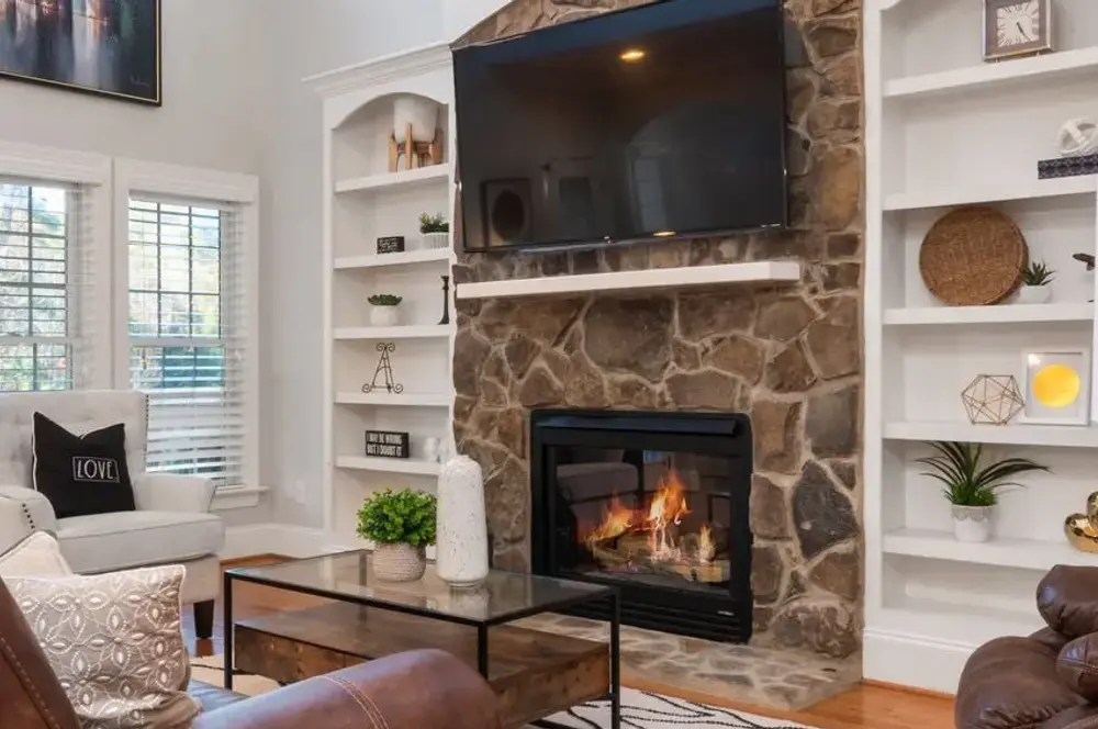 A fireplace glowing in a living room, the kind of radiant heat you feel on your skin from across the room